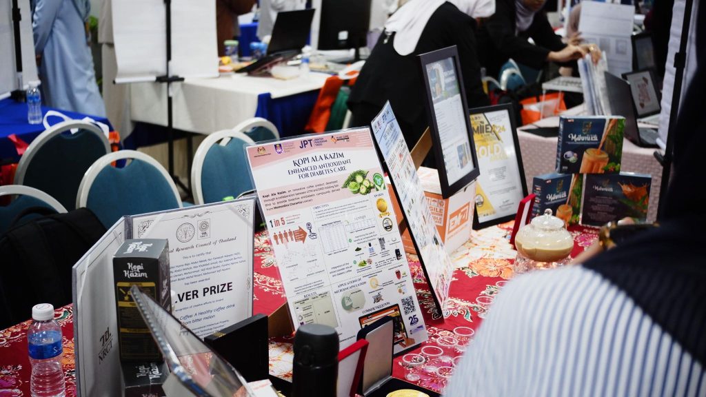 i-SIIDEC 2024: Booth with the Kopi Ala Kazim poster and product display