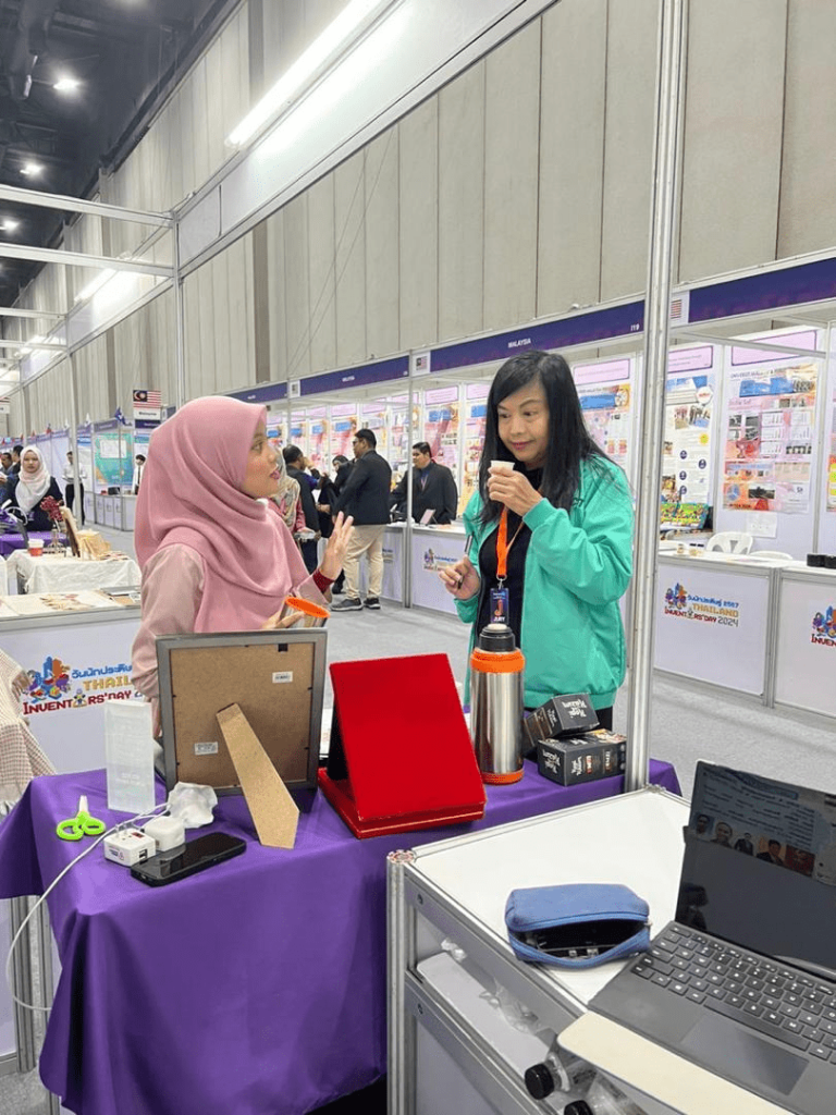 IPITEX 2024: A team member serving a visitor at the booth