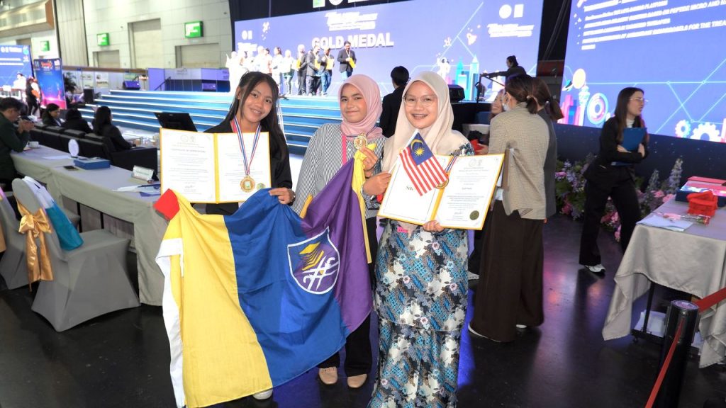 IPITEx 2025: Team members with the UiTM and Malaysian flags holding certificates